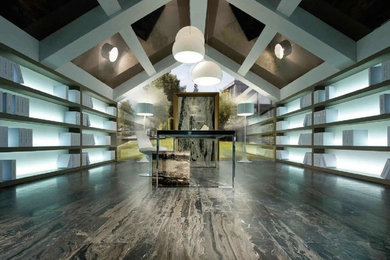 Diseño de despacho actual extra grande sin chimenea con paredes grises, suelo de madera en tonos medios y escritorio independiente