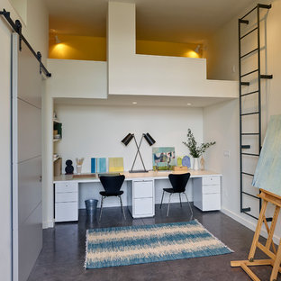 Inspiration för ett mellanstort funkis hobbyrum, med beige väggar, betonggolv, ett inbyggt skrivbord och grått golv