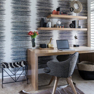 Bild på ett stort eklektiskt hemmabibliotek, med flerfärgade väggar, kalkstensgolv, ett fristående skrivbord och beiget golv