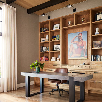 Transitional freestanding desk medium tone wood floor and brown floor home office photo in San Francisco with gray walls