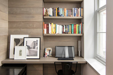 Modelo de despacho minimalista pequeño sin chimenea con paredes grises, suelo de madera en tonos medios, escritorio empotrado y suelo gris