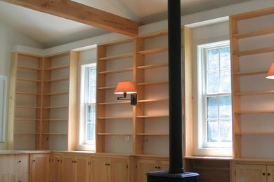 Modelo de despacho rústico de tamaño medio con paredes blancas, suelo de madera clara y escritorio empotrado