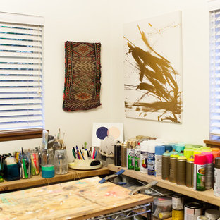 Cette photo montre un petit bureau sud-ouest américain de type studio avec un mur blanc, un sol en bois brun et un bureau indépendant.