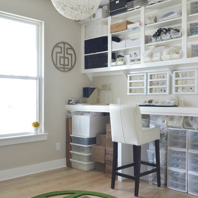 Craft room - contemporary built-in desk light wood floor craft room idea in Dallas with gray walls