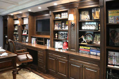 Foto de despacho tradicional de tamaño medio sin chimenea con paredes grises, suelo de madera oscura y escritorio empotrado