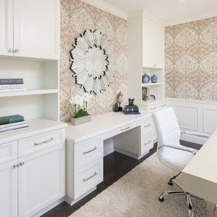 Mittelgroßes Klassisches Arbeitszimmer ohne Kamin mit Arbeitsplatz, rosa Wandfarbe, dunklem Holzboden, freistehendem Schreibtisch und braunem Boden in Los Angeles