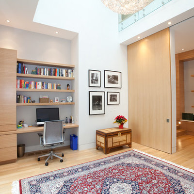 Example of a large trendy built-in desk light wood floor study room design in Toronto with white walls and no fireplace