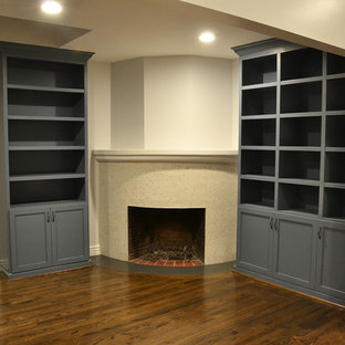 Exemple d'un bureau chic de taille moyenne avec un mur gris, un sol en bois foncé, une cheminée d'angle, un manteau de cheminée en pierre et un bureau intégré.