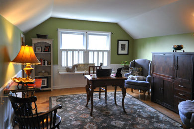 Klassisches Arbeitszimmer mit Arbeitsplatz, grüner Wandfarbe, hellem Holzboden und freistehendem Schreibtisch in Louisville