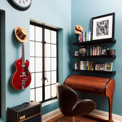 Example of an eclectic freestanding desk home office design in New York with blue walls