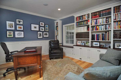 Diseño de despacho de estilo de casa de campo de tamaño medio sin chimenea con paredes azules, suelo de madera clara, escritorio independiente y suelo marrón