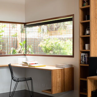 This is an example of a contemporary study room in Melbourne with white walls, dark hardwood floors, a built-in desk and brown floor.