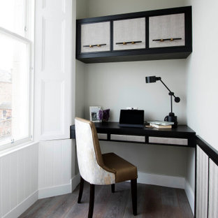 Inspiration for a traditional study in Other with grey walls, medium hardwood flooring, a built-in desk and brown floors.