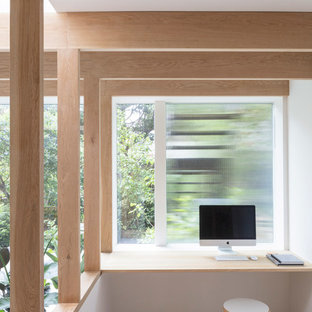 Design ideas for a scandi study in London with white walls, light hardwood flooring, a built-in desk and beige floors.