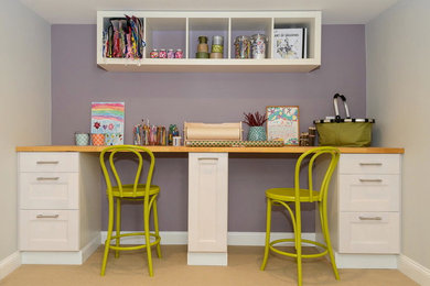 Foto de sala de manualidades tradicional renovada pequeña sin chimenea con paredes púrpuras, escritorio empotrado y suelo vinílico