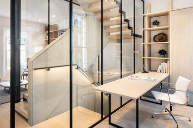 Ejemplo de despacho escandinavo de tamaño medio sin chimenea con paredes blancas, suelo de madera clara, escritorio independiente y suelo marrón