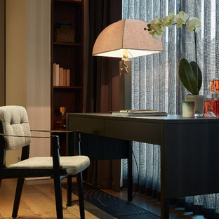 Inspiration for a contemporary home office in London with beige walls, medium hardwood flooring, a freestanding desk and brown floors.