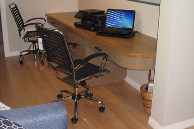Ejemplo de despacho clásico renovado de tamaño medio sin chimenea con paredes grises, suelo de madera en tonos medios, escritorio empotrado y suelo marrón