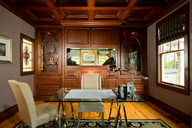 Imagen de despacho clásico con suelo de madera en tonos medios y escritorio independiente
