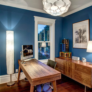 Mittelgroßes Uriges Arbeitszimmer mit blauer Wandfarbe, dunklem Holzboden und freistehendem Schreibtisch in Seattle