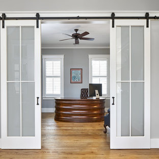 Study room - large transitional freestanding desk medium tone wood floor and brown floor study room idea in Charleston with gray walls