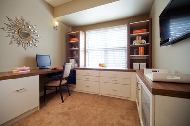 Foto de despacho clásico renovado de tamaño medio sin chimenea con paredes beige, moqueta y escritorio empotrado