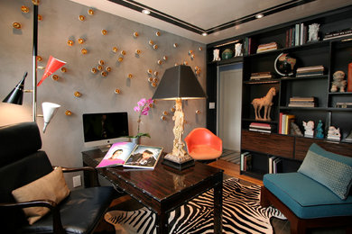Foto de despacho ecléctico con paredes grises, suelo de madera en tonos medios y escritorio independiente