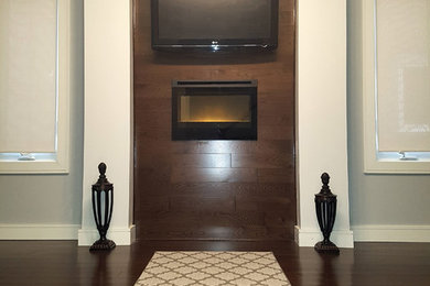 Foto di un ufficio minimalista di medie dimensioni con pareti grigie, parquet scuro, camino classico, cornice del camino in legno, scrivania autoportante e pavimento marrone