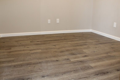 Example of a vinyl floor and brown floor home office design in Other