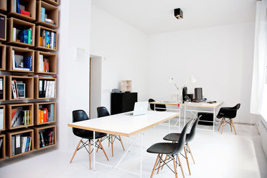 Kleines Modernes Arbeitszimmer ohne Kamin mit Studio, weißer Wandfarbe, Betonboden und freistehendem Schreibtisch in Hamburg