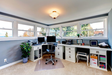 Ejemplo de despacho clásico grande sin chimenea con paredes azules y escritorio empotrado