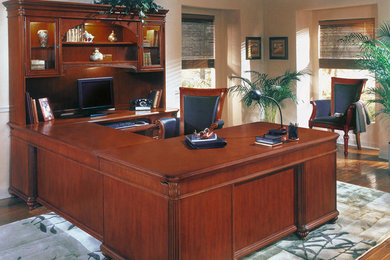Example of a built-in desk medium tone wood floor home office design in Boise with beige walls