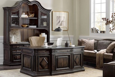 Ejemplo de despacho clásico grande sin chimenea con paredes beige, suelo de madera oscura y escritorio independiente