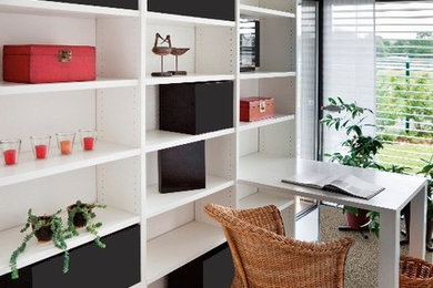 Ejemplo de despacho actual sin chimenea con paredes blancas, moqueta y escritorio empotrado