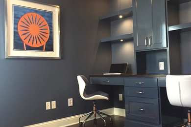 Imagen de despacho moderno sin chimenea con paredes azules, suelo de madera oscura, escritorio empotrado y suelo marrón