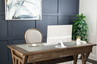 Diseño de despacho moderno de tamaño medio con paredes blancas, suelo de madera oscura, escritorio independiente y suelo marrón