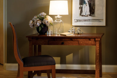 Imagen de despacho de estilo americano de tamaño medio con paredes beige, escritorio independiente y suelo de madera clara