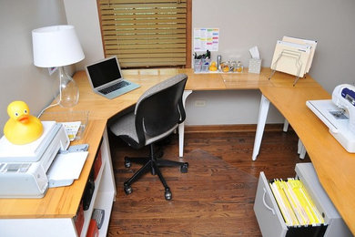 Diseño de sala de manualidades minimalista de tamaño medio sin chimenea con paredes grises, suelo de madera en tonos medios y escritorio independiente