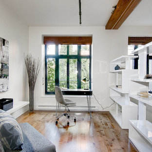 Idee per un piccolo atelier minimal con pareti bianche, pavimento in legno massello medio, camino classico, cornice del camino in intonaco, scrivania autoportante e pavimento marrone