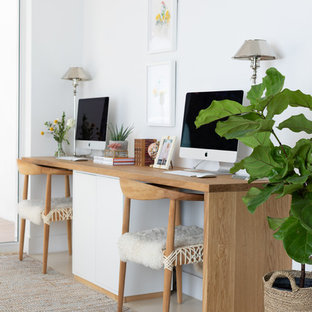 Exempel på ett mellanstort maritimt hemmabibliotek, med vita väggar, betonggolv, ett fristående skrivbord och beiget golv