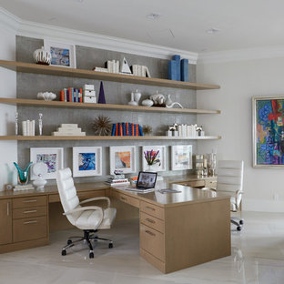 Modern inredning av ett mellanstort hemmabibliotek, med marmorgolv, ett inbyggt skrivbord, vita väggar och vitt golv