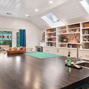 Großes Retro Nähzimmer mit weißer Wandfarbe, Vinylboden, Einbau-Schreibtisch, braunem Boden, Holzdielendecke und Holzdielenwänden in Atlanta