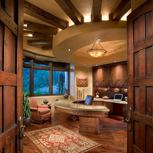 Idée de décoration pour un grand bureau sud-ouest américain avec un mur beige, un sol en bois brun, un bureau intégré, aucune cheminée et un sol marron.