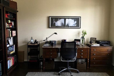 Example of a mid-sized minimalist freestanding desk dark wood floor and black floor study room design in Houston with beige walls and no fireplace