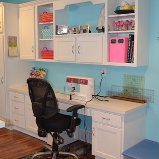 Mittelgroßes Modernes Nähzimmer mit blauer Wandfarbe, braunem Holzboden und Einbau-Schreibtisch in Grand Rapids