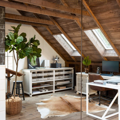 Large farmhouse freestanding desk light wood floor and brown floor study room photo in Boston with white walls