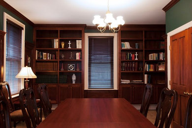 Example of a mid-sized classic freestanding desk travertine floor and beige floor home office library design in Providence with green walls and no fireplace