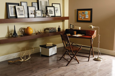 Mittelgroßes Klassisches Arbeitszimmer mit Arbeitsplatz, bunten Wänden, braunem Holzboden, freistehendem Schreibtisch und braunem Boden in Sonstige