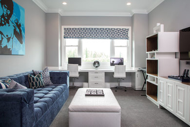 Example of a large transitional built-in desk carpeted home studio design in Los Angeles with gray walls
