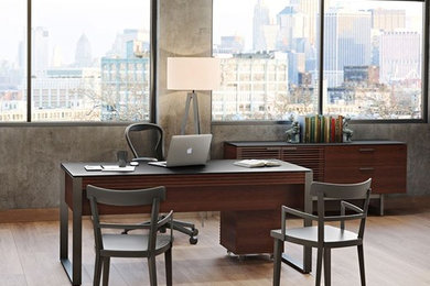 Imagen de despacho contemporáneo de tamaño medio sin chimenea con paredes grises, suelo de madera clara y escritorio independiente
